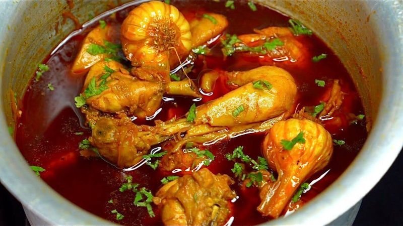 Chicken handi simmering in a deep pot with fresh coriander