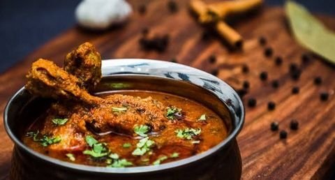 Kadhai chicken in a steel handi with whole spices and bay leaf